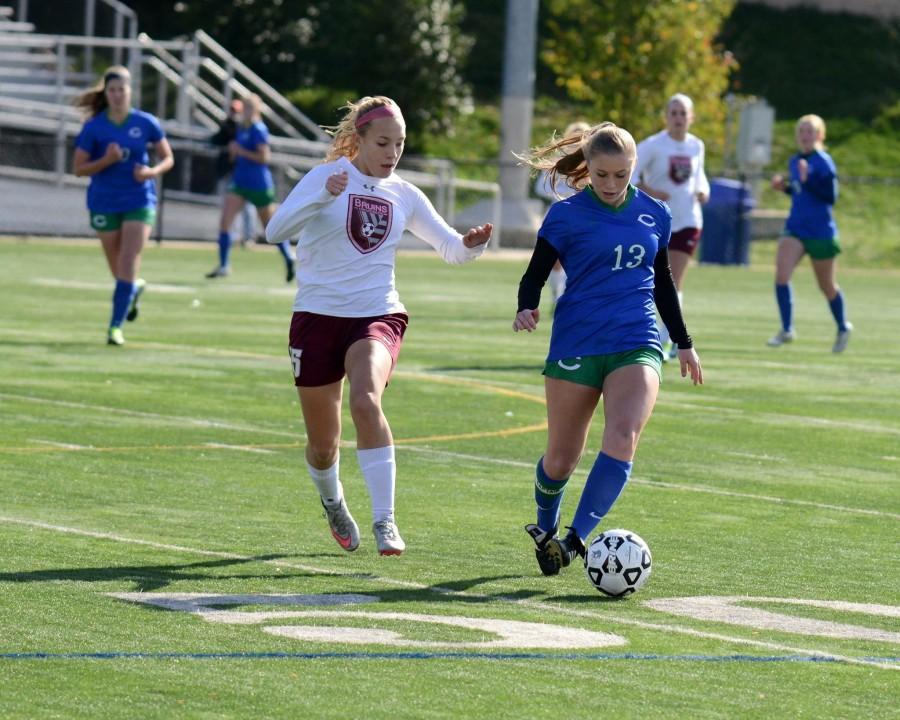 Senior Juliana Comer (right) dribbles past a defender in the state semifinal game.