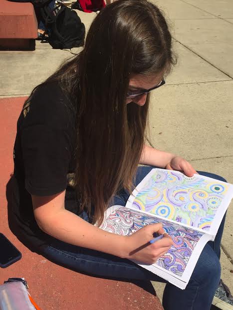 Freshman Emma Gray relaxes with an adult coloring book.