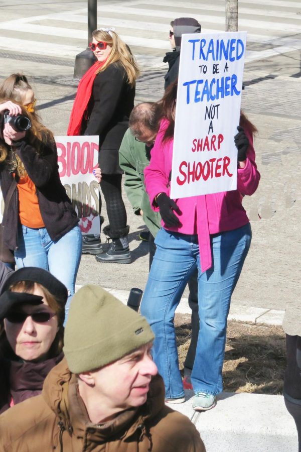 Teachers at a March 2018 protest hold up signs against the proposal of a law that mandates school teachers to be armed.