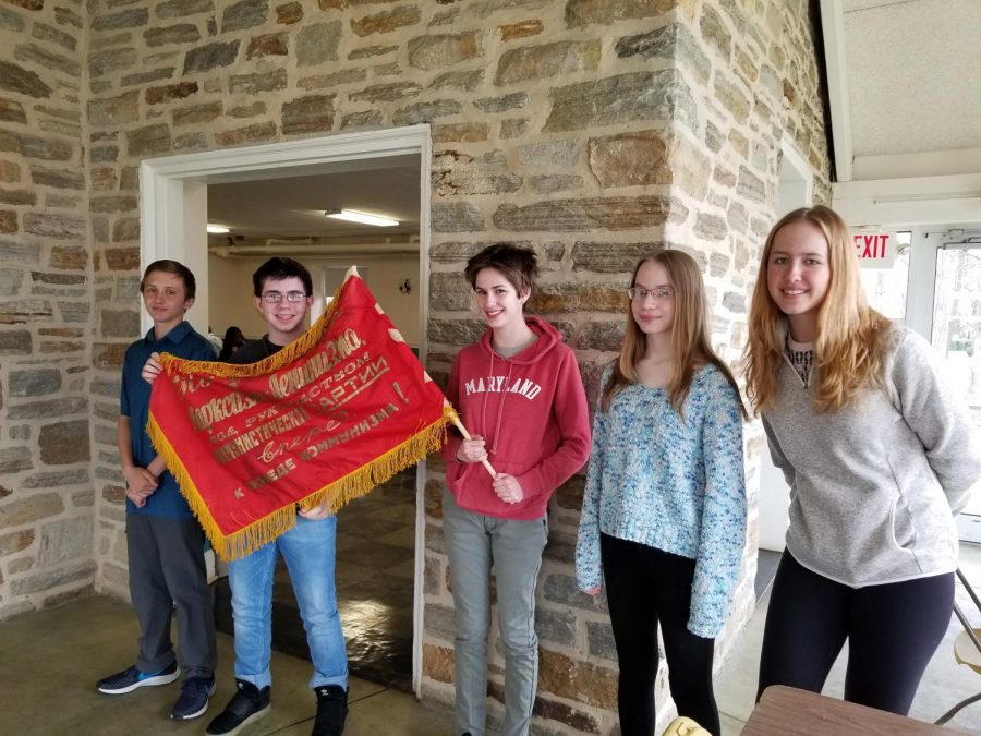 (Left to right) Jackson Will, Amiel Bengert, Gloria Herman, Veronica Starchenko and Anastasia Avrine, all level 3 Russian students, stand with a Russian Soviet Flag at Russian Olympiada.