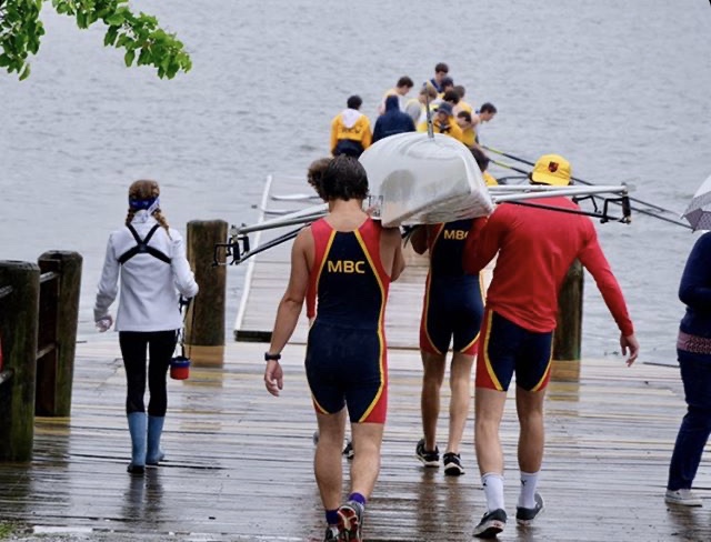 Members of the Montgomery Boat Club carry a shell to the water at the previous practice location, the Anacostia River. Practicing here was difficult due to the long travel times, which led to a short amount of time in the water and late arrivals, as well as the limited space available for them to prepare for races. 