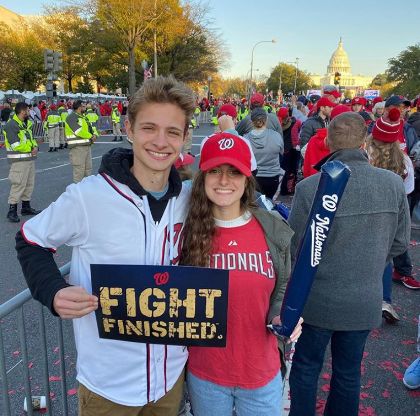Senior Jeremy Ashe (left) stands along Constitution Ave. for the Nationals “Nats” Parade, sporting the baseball team in support of their recent World Series win.