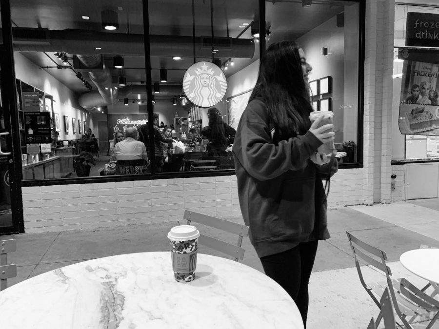 Sophomore Naz Yavuz stands outside of Starbucks at the Cabin John Shopping Center on a chilly night, drinking a hot and iced matcha latte from Starbucks.