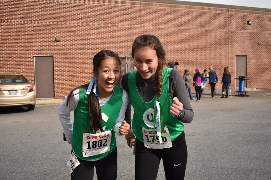 Lauren Kuo (left) and Jessica Bowen (right) get pumped up before their 2019 State Cross Country Meet.  Kuo and Bowen have been on the team since freshman year and were disappointed when their last season was cancelled. 
