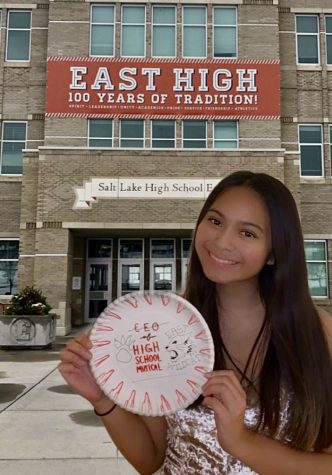 Senior Hannah Zozobrado poses at East High, the fictional high school from the High School Musical franchise. She holds up a paper plate, a signature activity of many banquets.