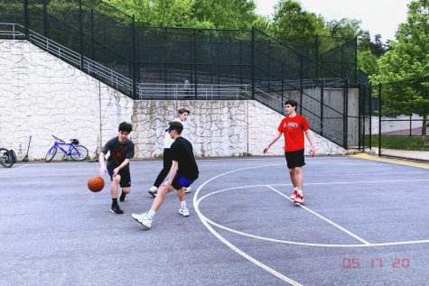 Dribbling a basketball towards a defender, Zack Mantz (left) plays basketball during his freetime at Cabin John Middle School against some of his closest friends.
