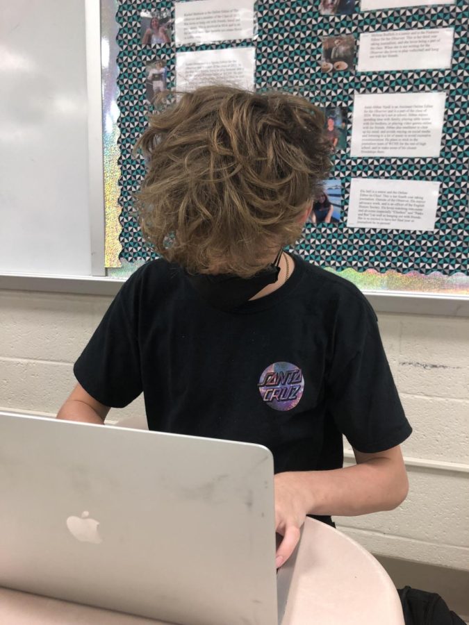 Junior Jack Gans completes schoolwork on his personal MacBook. Instead of bringing his issued Chromebook to school, Gans brings his own computer because he is more used to it. 