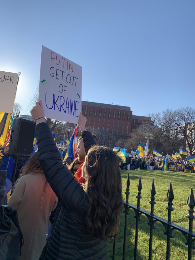 Kira Breslawec stands proudly holding a poster at a protest against Russias invasion of Ukraine. Protests have occured all around the world, including the nations capital to object Putins treatment of Ukraine. 