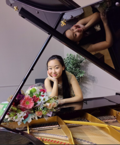 On March 26, sophomore Maddie Xu smiles behind the piano after her successful performance at the Arc Montgomery Piano Fundraiser at Piano Craft Gaithersburg.