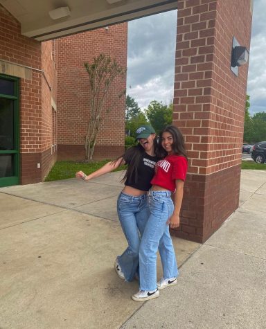 WCHS seniors Sanaz Wycoff and Hannah Schulsinger pose together outside of the school building in shirts with their colleges on it on May 1, 2023.