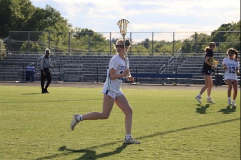 Ella Carnathan, a freshman on the WCHS Girls Varsity Lacrosse team, receives the ball and pivots to carry it up field toward the goal.