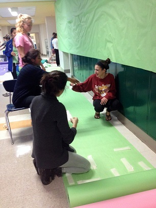 Current seniors Jessie Gloger, Tanya Dhingra and Crystal Mehdizadeh set up for 2013 homecoming in the CHS hallways.