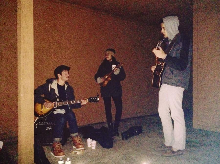 Dhingra (center) makes a brief appearance on stage, strumming a ukulele along with the guitar-performing duo Dec. 10.