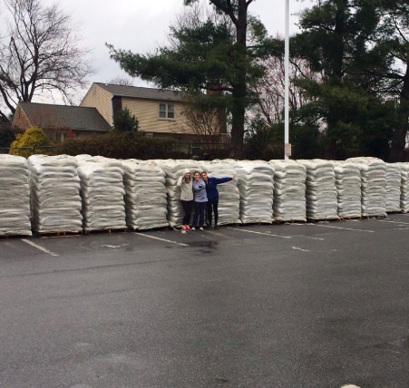 Students stand in front of piles of mulch to be delivered in the 2014 mulch sale.