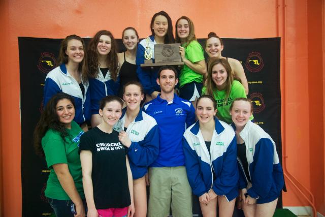 The girls swim team stands with coach Chris Tappis after its win. 