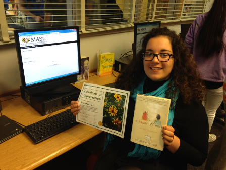 Sophomore Tara Manzari holding up her favorite BES book and her certificate for having read at least three books.