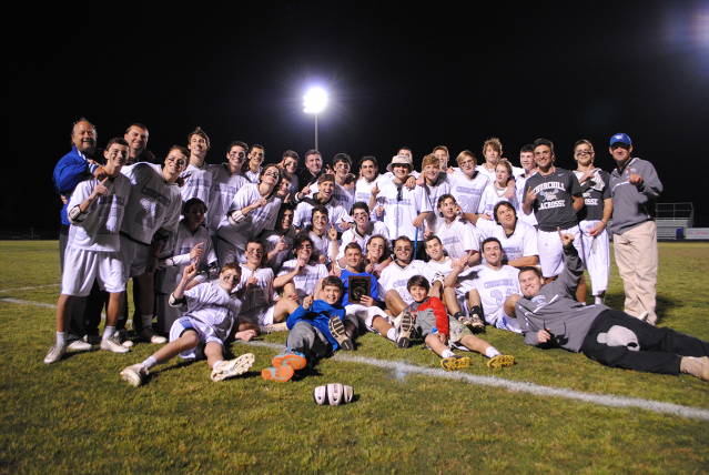 The CHS boys lacrosse team poses with the regional championship plaque after their 10-9 2OT win against QO