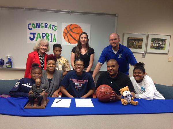 Karim-Duvall gathers with her family, coach Katelyn McMahon, Principal Joan Benz and athletic director Scott Rivinius to celebrate her commitment