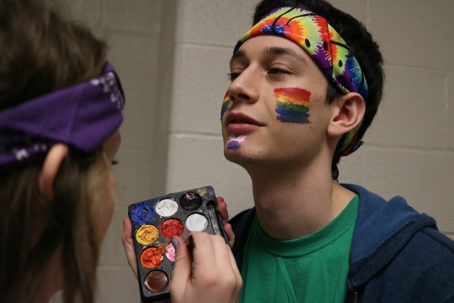 Senior Elanore Fuller paints rainbow on senior Michael Levines face on CHS Unity Day. 