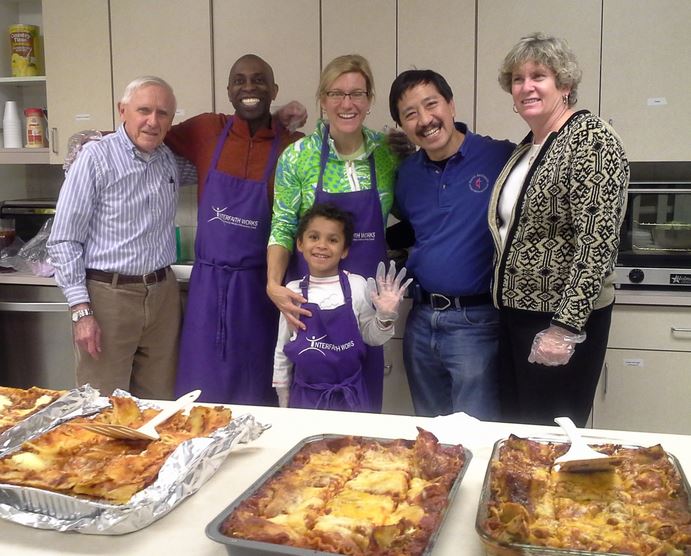 A group of volunteers prepares a meal for the residents of the Carroll House, a housing unit through Interfaith Works.