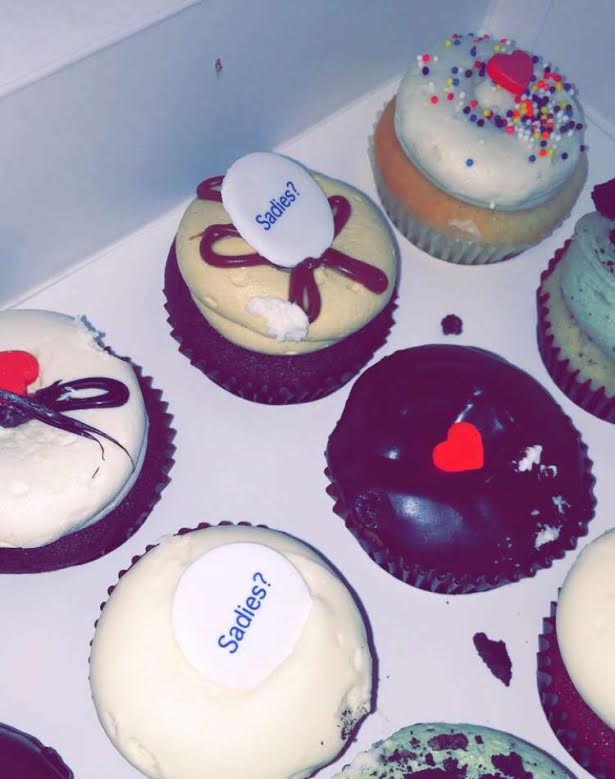 A student “proposes” with a cupcake.