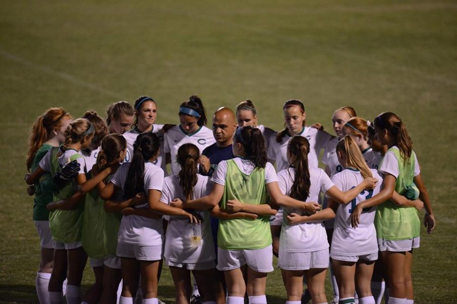 Before a game, the varsity girls soccer team huddles around their coach, Haroot Hakopian. Despite finishing third in the state, fewer CHS fans attend their games compared to the boys soccer games. 