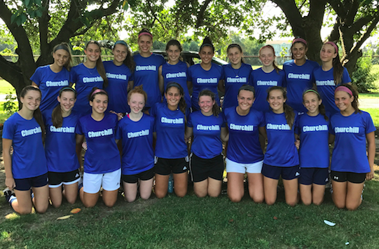 The Girls Varsity Soccer Team poses for a team photo outside the field after a game.