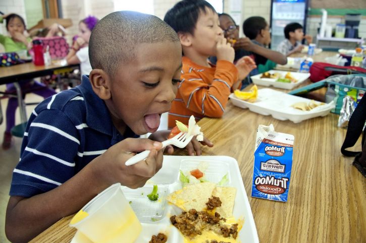  A student eats a meal provided to him during the summer time.