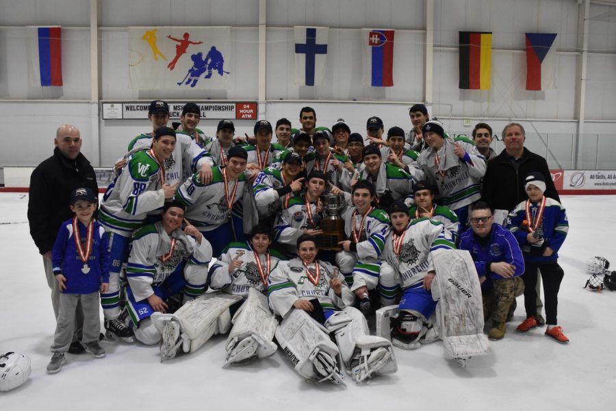 WCHS hockey coaches pose with the team after winning the state championship last year.