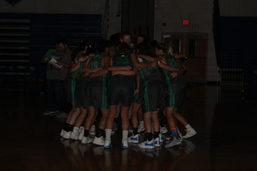 The Varsity Girls Basketball team huddles before the start of the event.