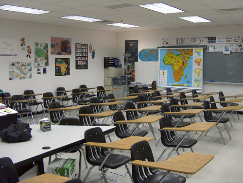 The stereotypical classroom of wooden desks and chairs awaits high school students.