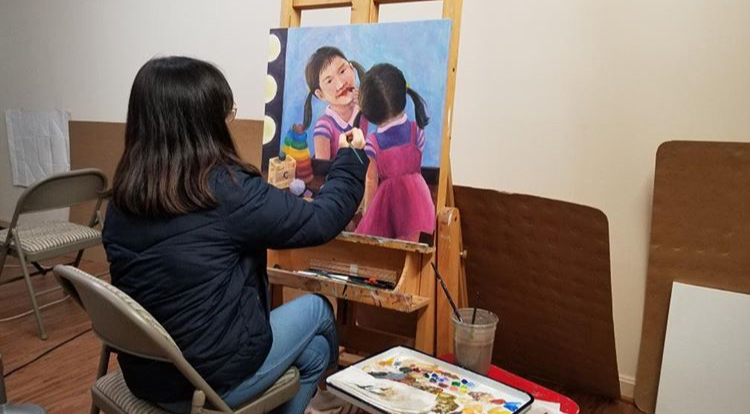 Artist Claire Yang at work, painting on canvas for John’s Hopkinss art competition. 