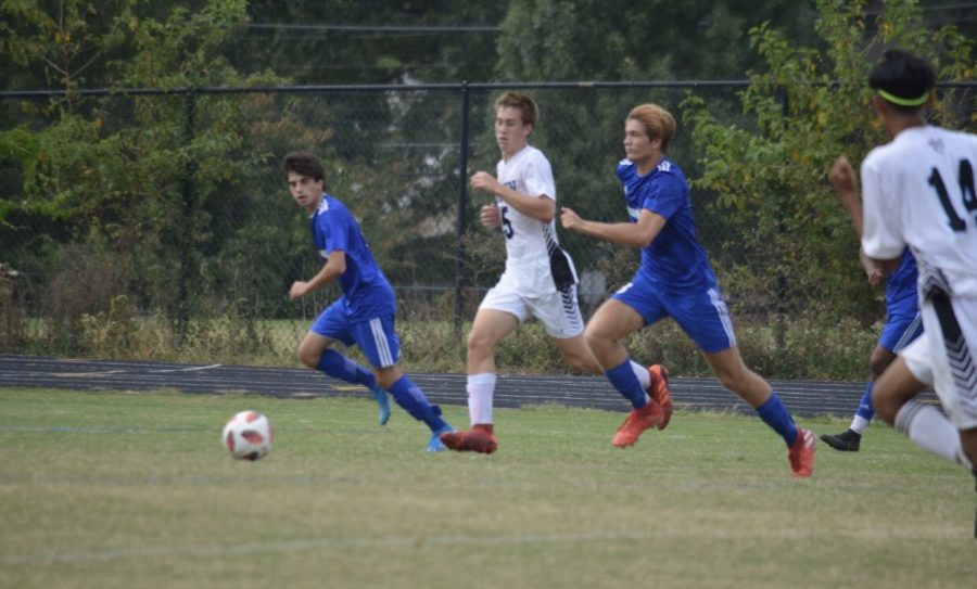 Mateo Noguera (right, blue) has been playing soccer since he was three years old. Now as a senior captain, Noguera still shines on the field.