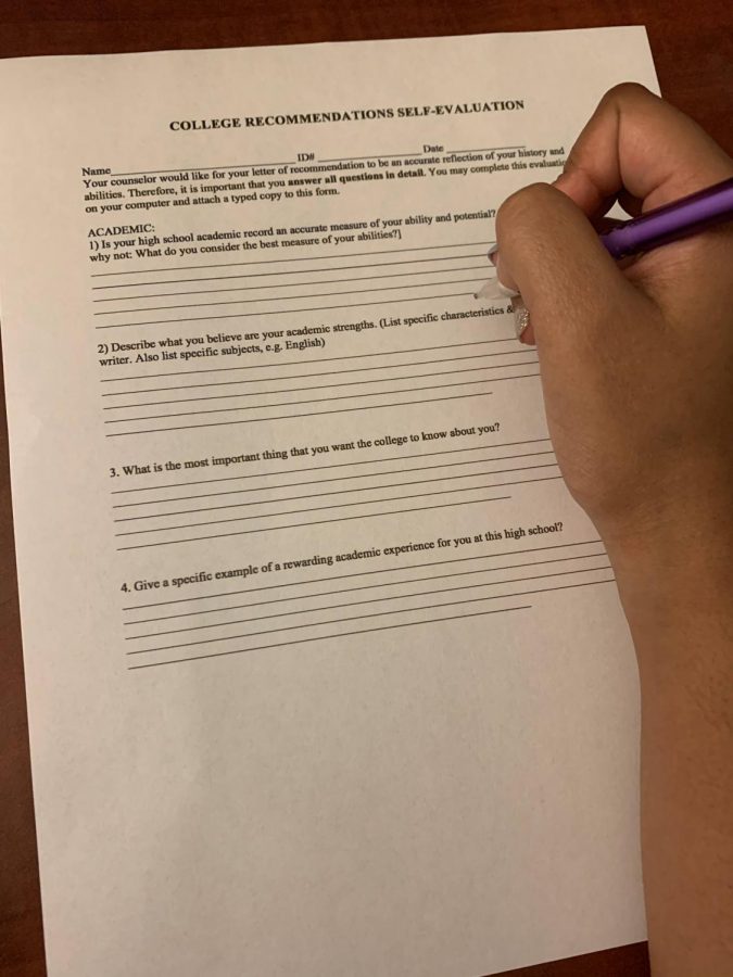 A WCHS student hands a recommendation letter template to give her teacher an idea of what to write.