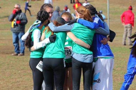 Runners on WCHS varsity cross country engage in a team huddle up before a race. They whisper words of encouragement and hype up their fellow Dawgs.