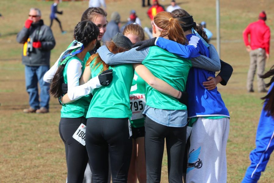 Runners+on+WCHS+varsity+cross+country+engage+in+a+team+huddle+up+before+a+race.+They+whisper+words+of+encouragement+and+hype+up+their+fellow+Dawgs.