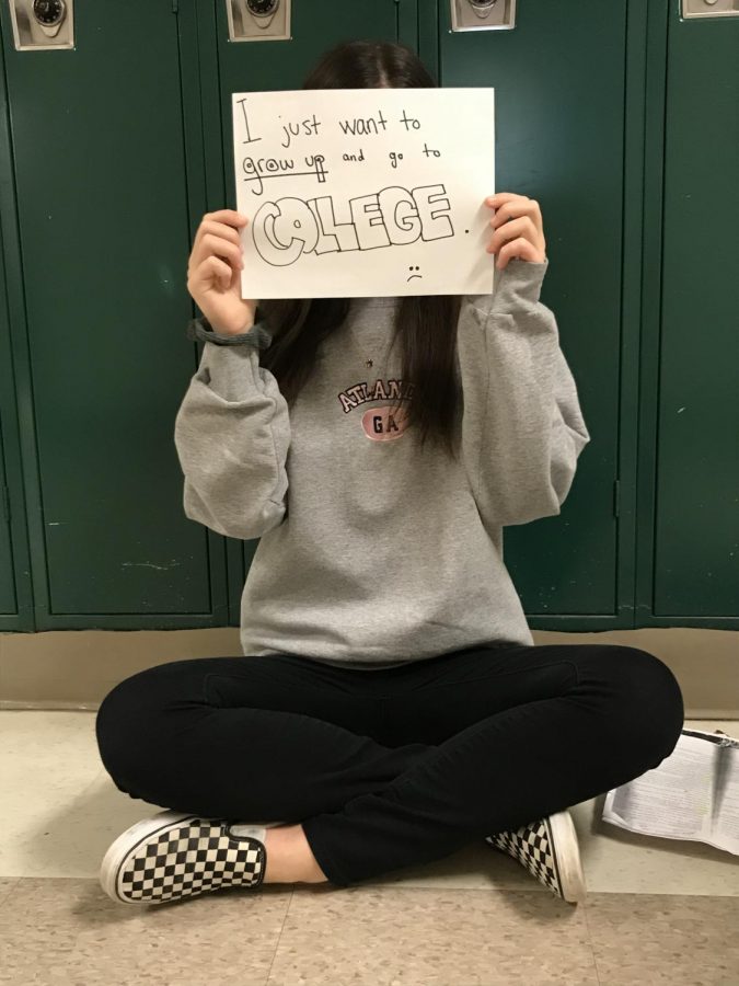 Sophomore Aliki Dimitoglou holds up a paper that says “I just want to grow up and go to college,” reflecting the general attitude of many students at WCHS.
