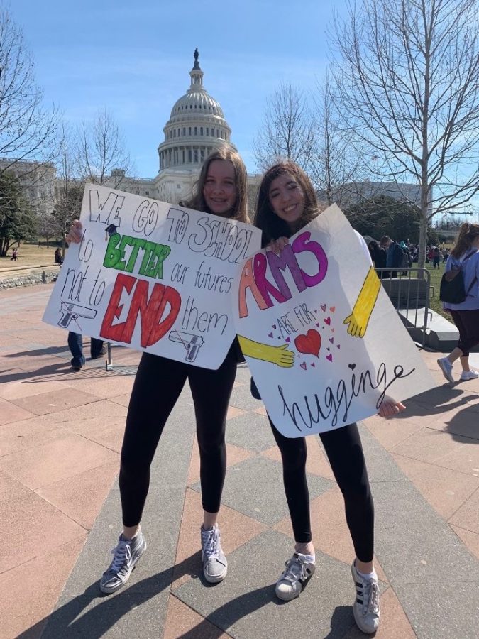 Sophomores Juli Magud and Maddie Reeve pose with handmade posters at a protest for gun control in D.C. They made it a goal to be more politically active.