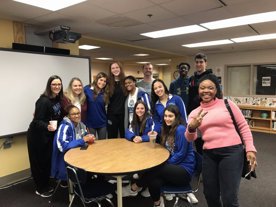Members of WCHS varsity basketball team pose with their teachers in the media center during an appreciation coffee for staff.