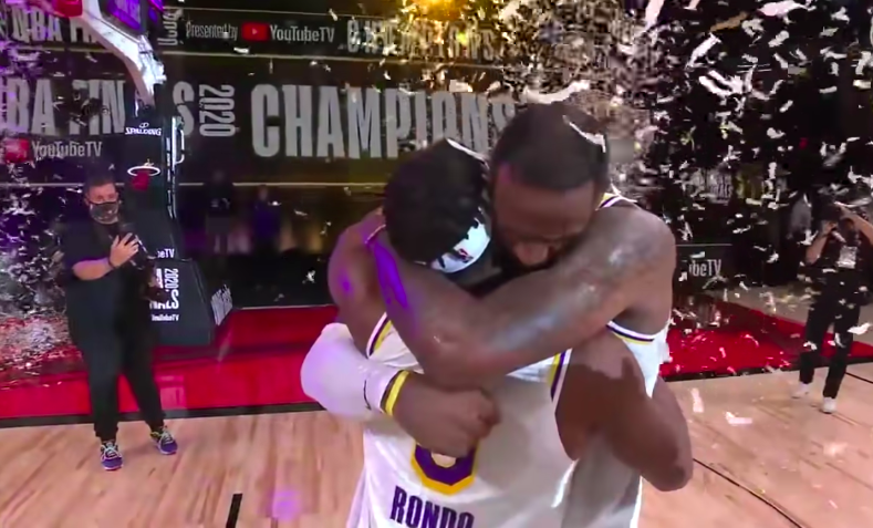 Confetti falling from the sky, LeBron James and Rajon Rondo are pictured hugging eachother and exchanging emotional words. Rondo and James won their first championship together as teammates on the Los Angeles Lakers.