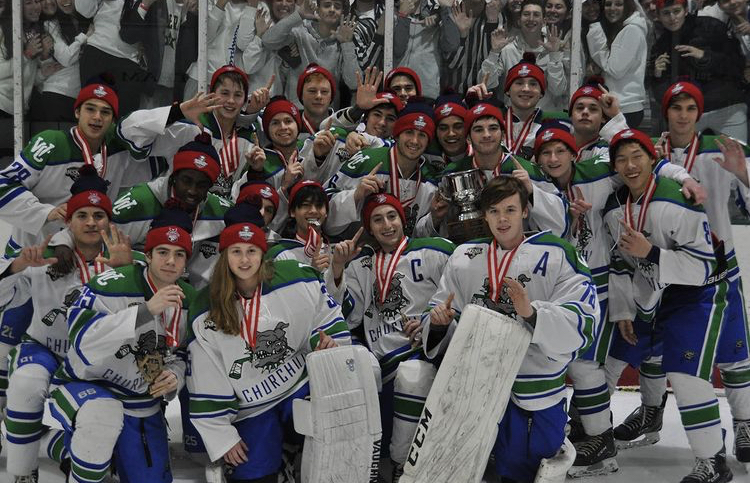 After winning their sixth straight Maryland State Championship in 2020, the WCHS hockey team poses for a group photo on the ice right after the game. The players are wearing their championship medals and hats.