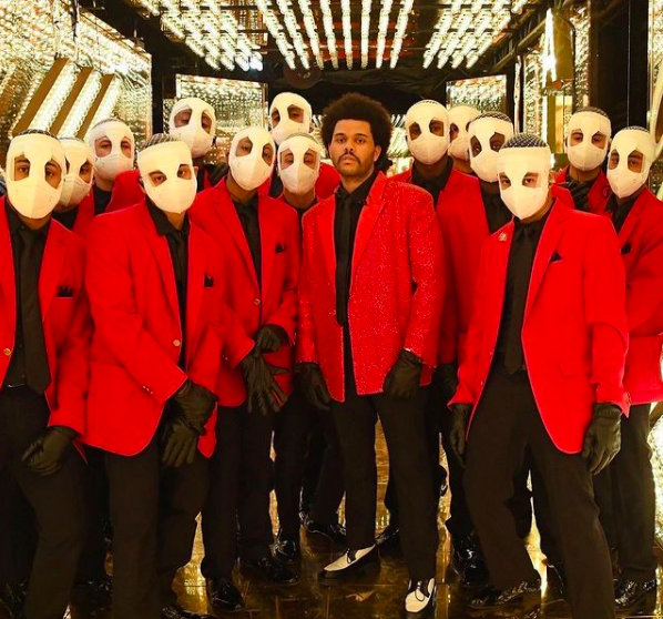 Inside one of his many Super Bowl Halftime Show backdrops, The Weeknd stands side by side a few of his extras for the performance. The extras were dressed to look like clones of The Weeknd for the February 7th performance.