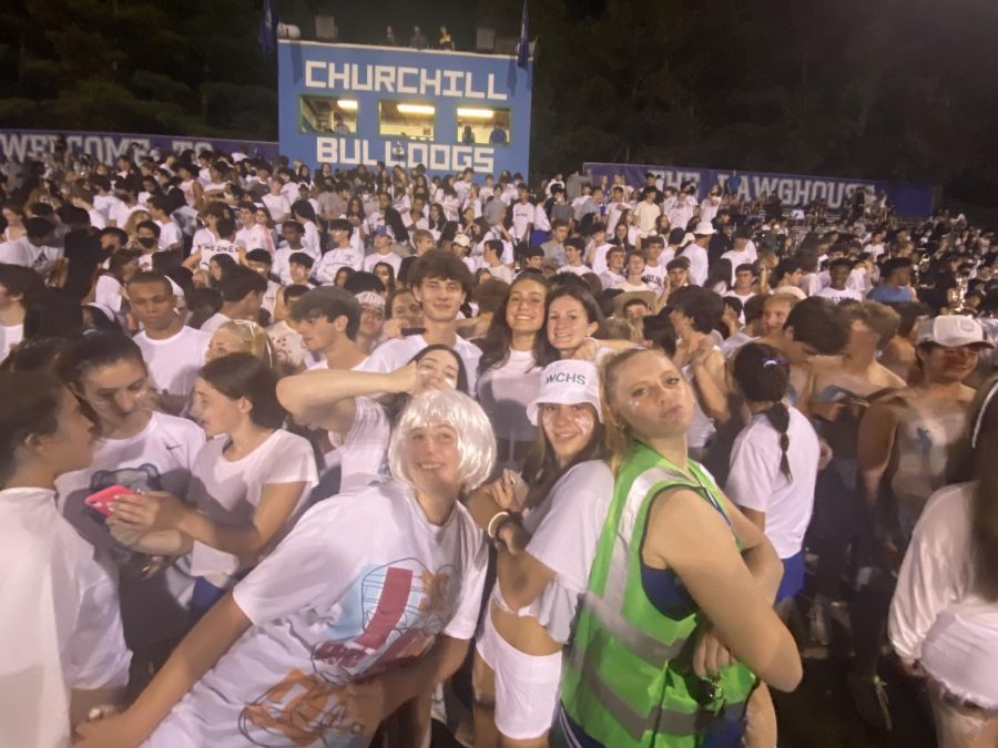 Seniors spirited in the white out theme pose at the bottom of the student section. The hype and fun of games have helped to bring out bigger crowds and fill the bleachers.