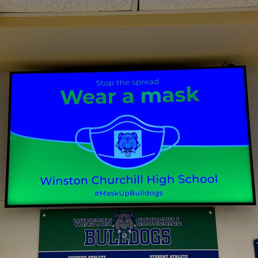 A+TV+screen+displays+a+wear+a+mask+graphic+in+the+hallway.+WCHS+already+implements+many+health+measures%2C+but+may+create+more+if+increased+transmission+occurs+from+the+Omicron+variant.