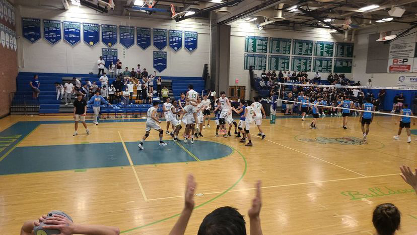 The boys varsity volleyball team jumps in victory after scoring the winning point for the game against Clarksburg team on March 21, 2022.
