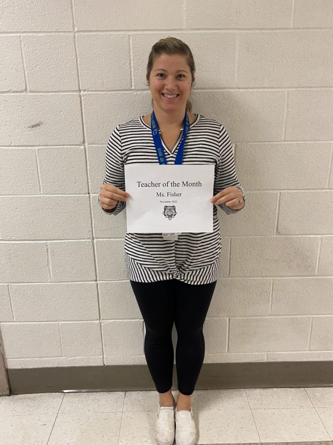 Ms. Fisher, shown holding up her Teacher of the Month certificate, teaches both AP AB Statistics and Intro to Statistics. She has taught for 17 years at WCHS. 