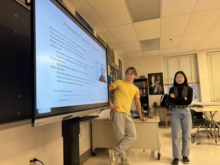 Philosophy and ethics club vice president, Josh Heimlich, intensely reflects in front of a presentation regarding philosophy of economics.