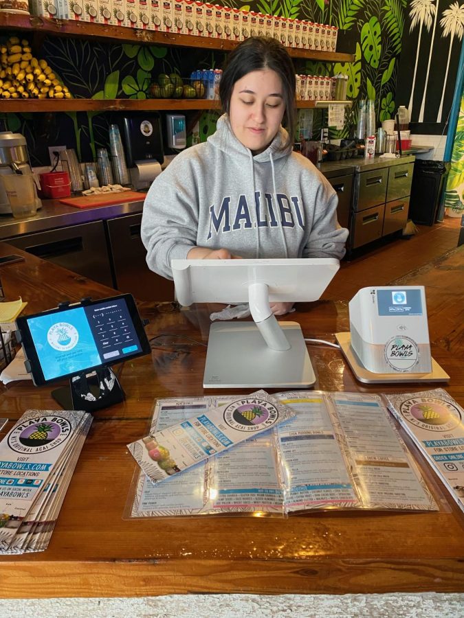 Li Turner, a worker at Playa Bowls, a popular counter service restaurant in Cabin John Village, uses an electronic tablet to checkout a customer. Playa Bowls uses the tablets to make the ordering process more convenient for customers and workers, and it prompts customers to leave a tip at the end of checkout. 