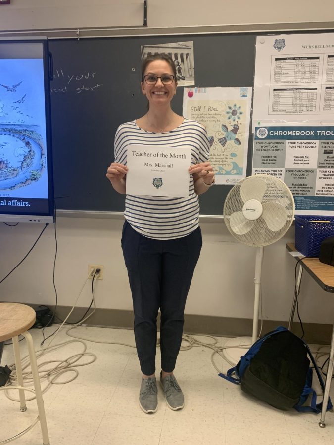 Mrs. Marshall, shown holding her Teacher of the Month sign, currently teaches AP U.S. History and Honors NSL. She has been a teacher for 17 years, all of which have been at WCHS.