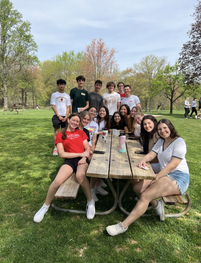 Seniors gather around a table together hanging out at Senior Day on April 14. Senior Day consisted of many games, sports, food and drinks for all seniors.